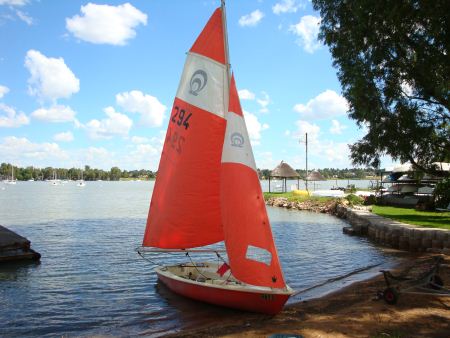 Small sailboat with red sails